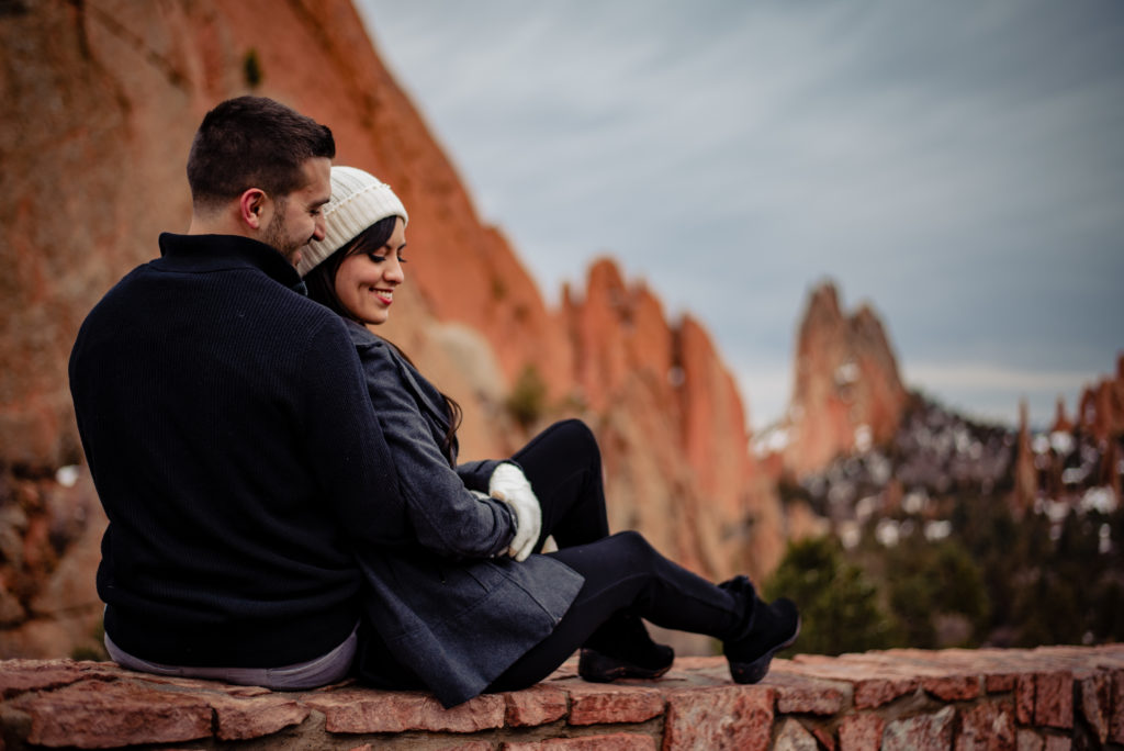Scenic viewpoint at Garden of the Gods, the couple snuggles up in their warm coats to brave the weather for their engagement session. 
