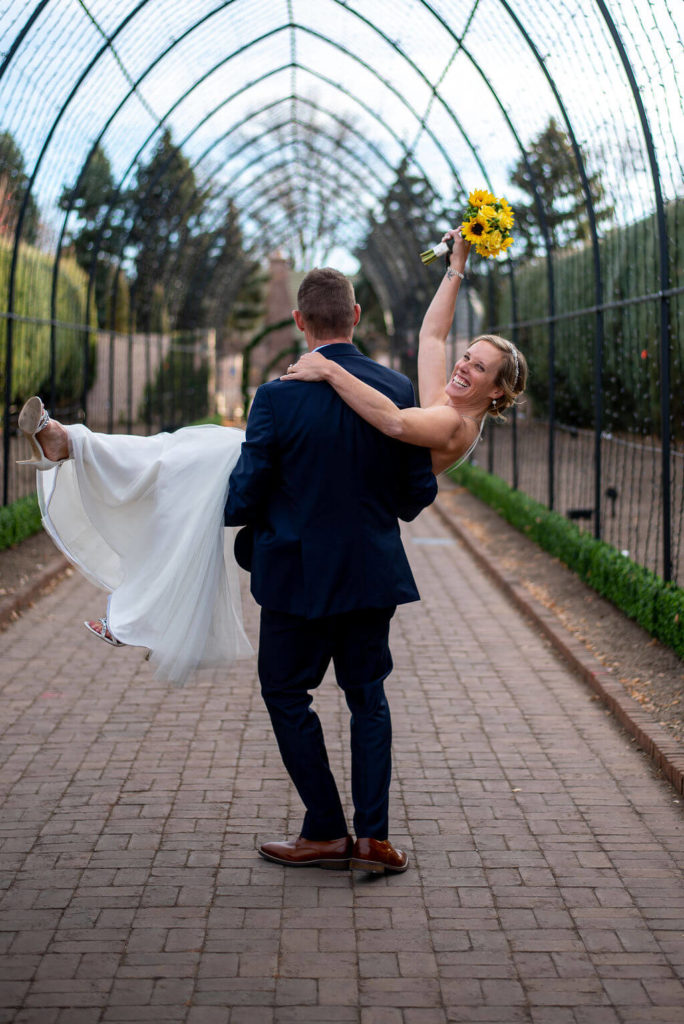 Groom sweeps bride off her feet at the Denver Botanic Gardens after their wedding