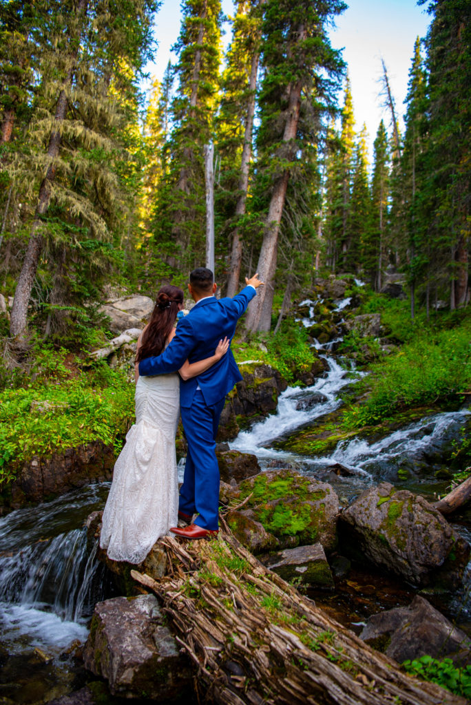Bride and groom explore a water fall during their Crested Butte elopement 