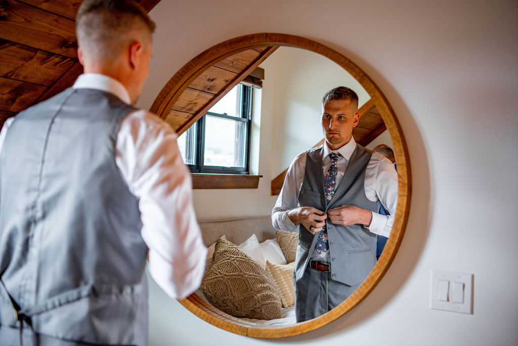 Groom looks in a mirror as he gets ready for his Estes Park Elopement