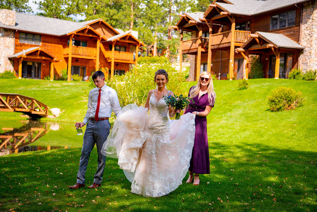 Bride walks with her friends towards her fiancé for her first look before her Estes Park elopement. 