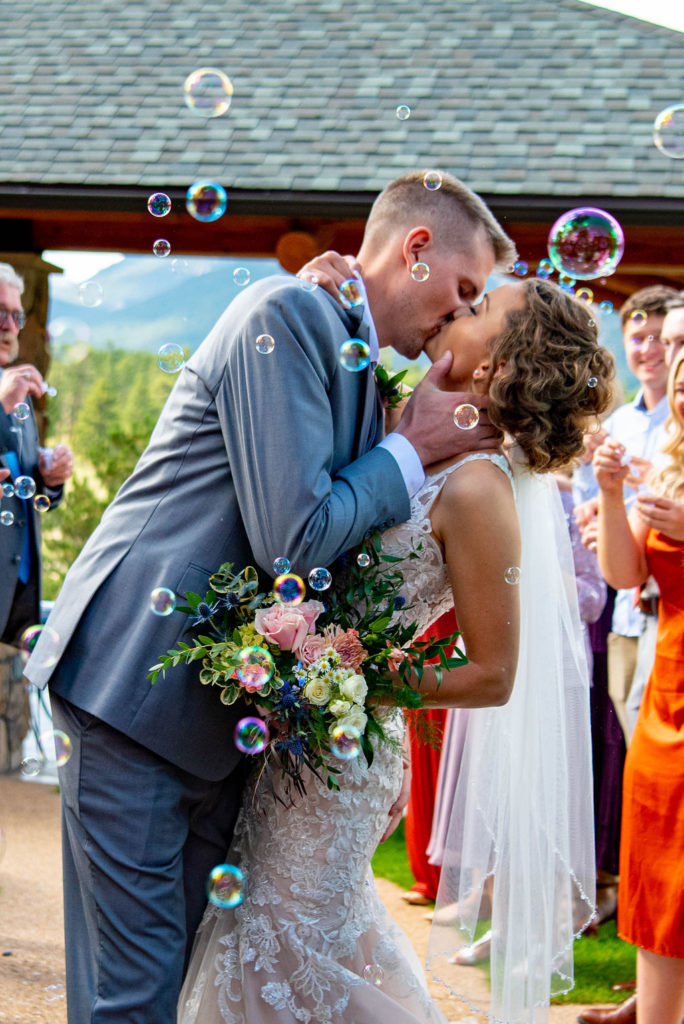 Bride and groom kiss surrounded by bubbles during their Estes Park elopement