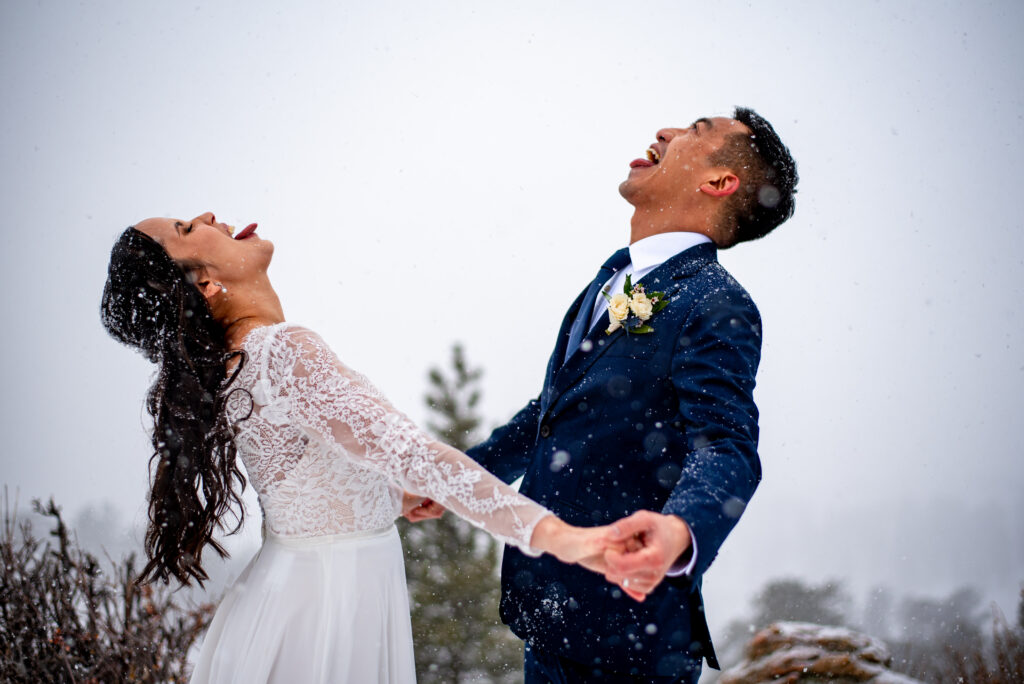 bride and groom catching snowflakes in their mouths during their crested butte winter elopement