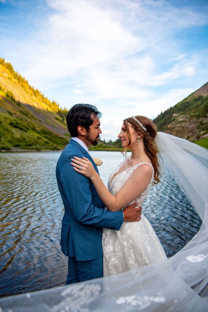 romantic bride and groom by an alpine lake