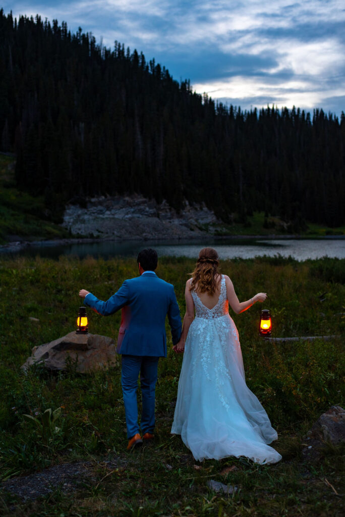 bride and groom holding lanterns during the dark