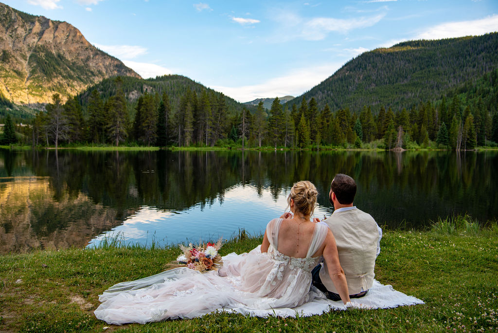 bride and groom colorado elopement picnic overlooking a lake and mountains