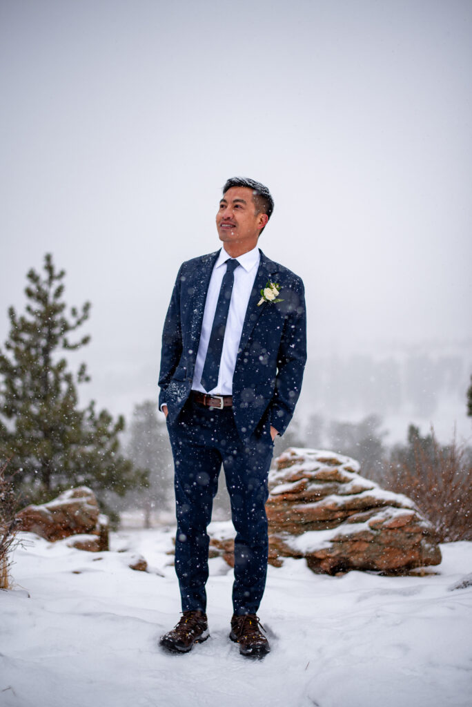 groom portrait while snow is slowly falling