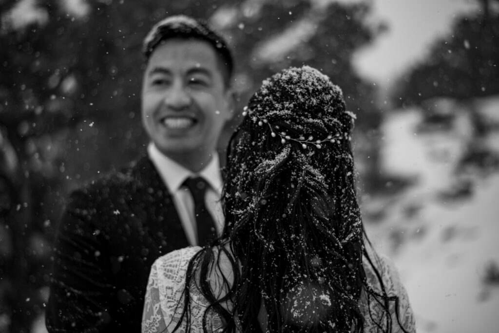 bride and groom covered in snowflakes during their Colorado winter wedding