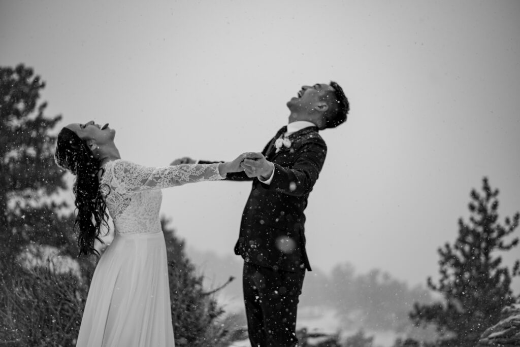 bride and groom catching snowflakes during their Colorado winter wedding