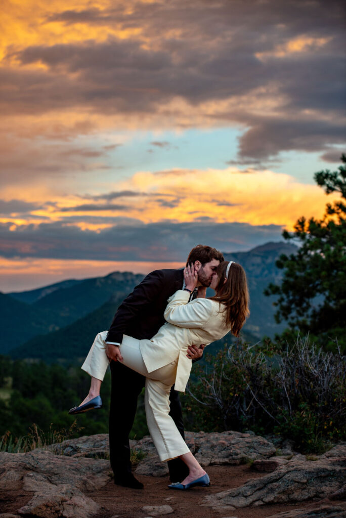 groom dipping his bride on a mountain top