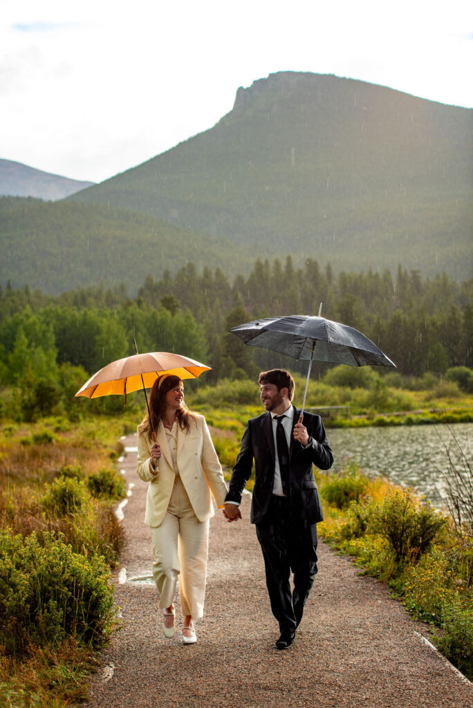 bride and groom taking a stroll holding umbrellas