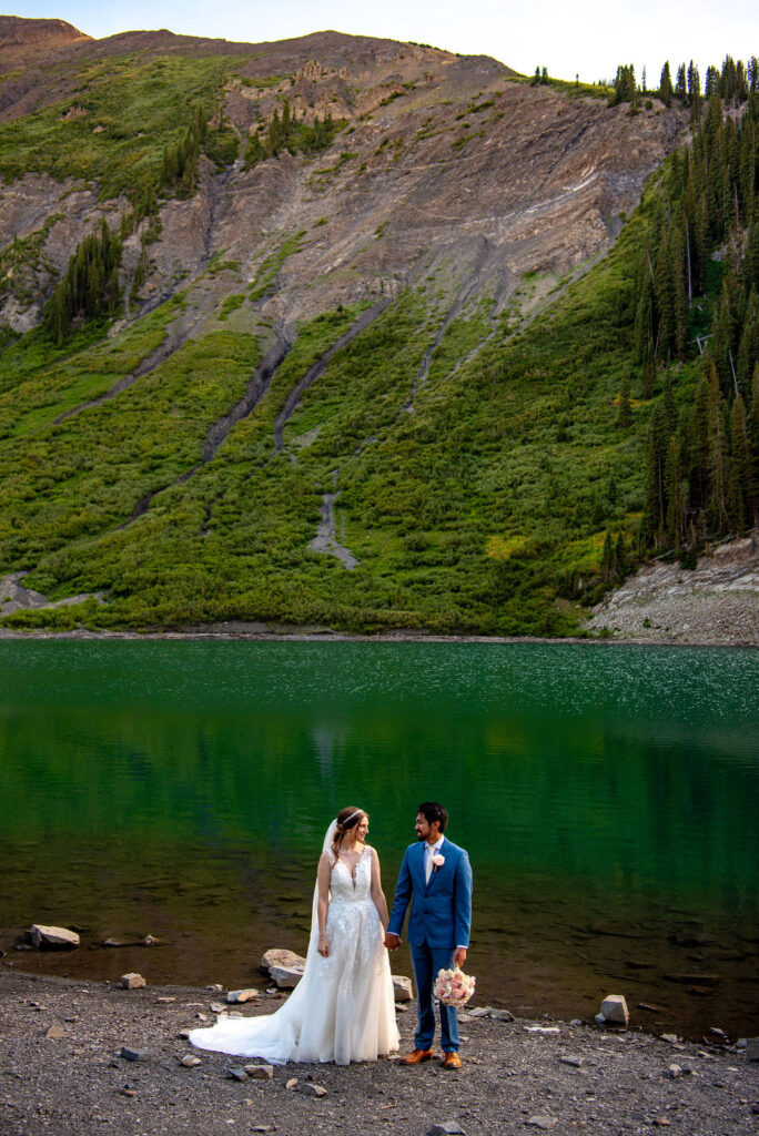 bride and groom in front of a lake in colorado