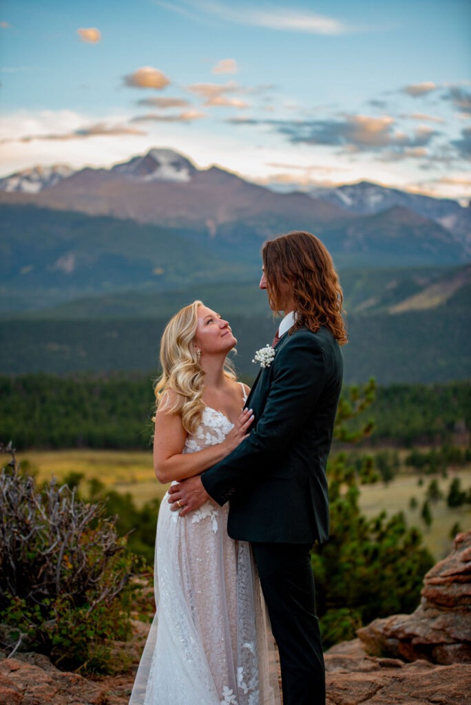 playful bride and groom photos during their elopement in colorado with mountains in the backdrop