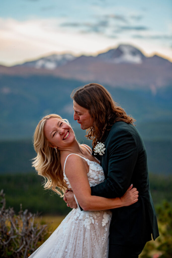 playful bride and groom photos during their elopement in colorado with mountains in the backdrop