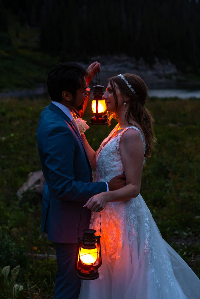 bride and groom posing with lanterns during their nighttime elopement photos