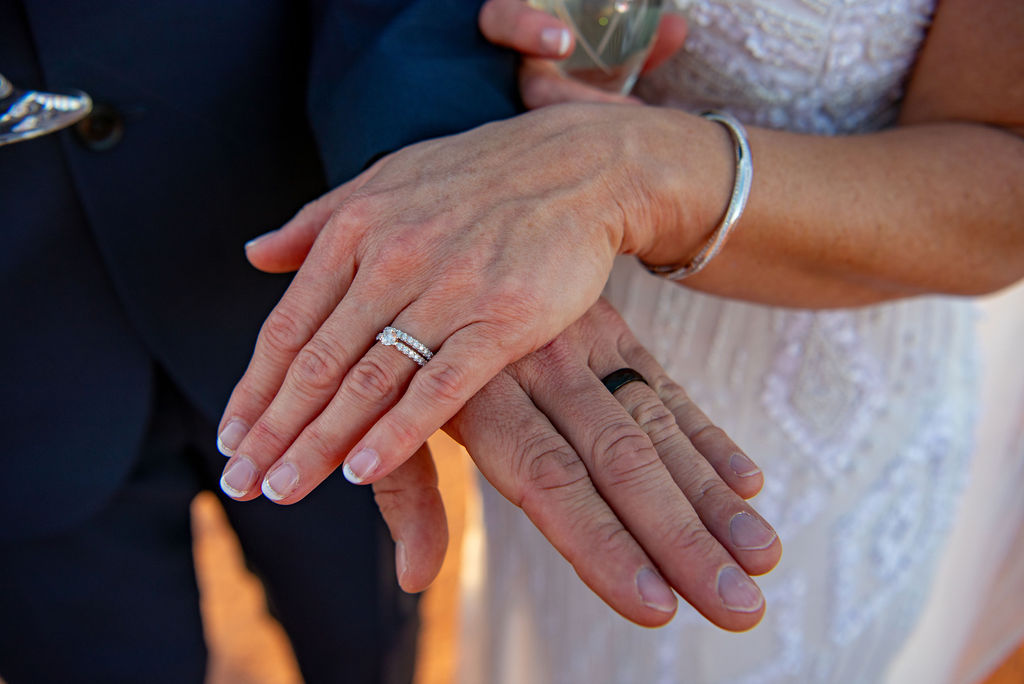 a close up of hands with wedding rings