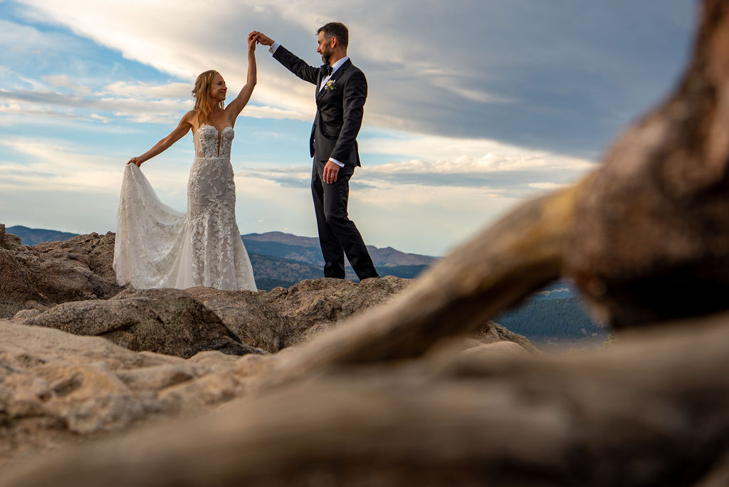 happy adventure elopement couple with the bride spinning around, her wedding dress flowing