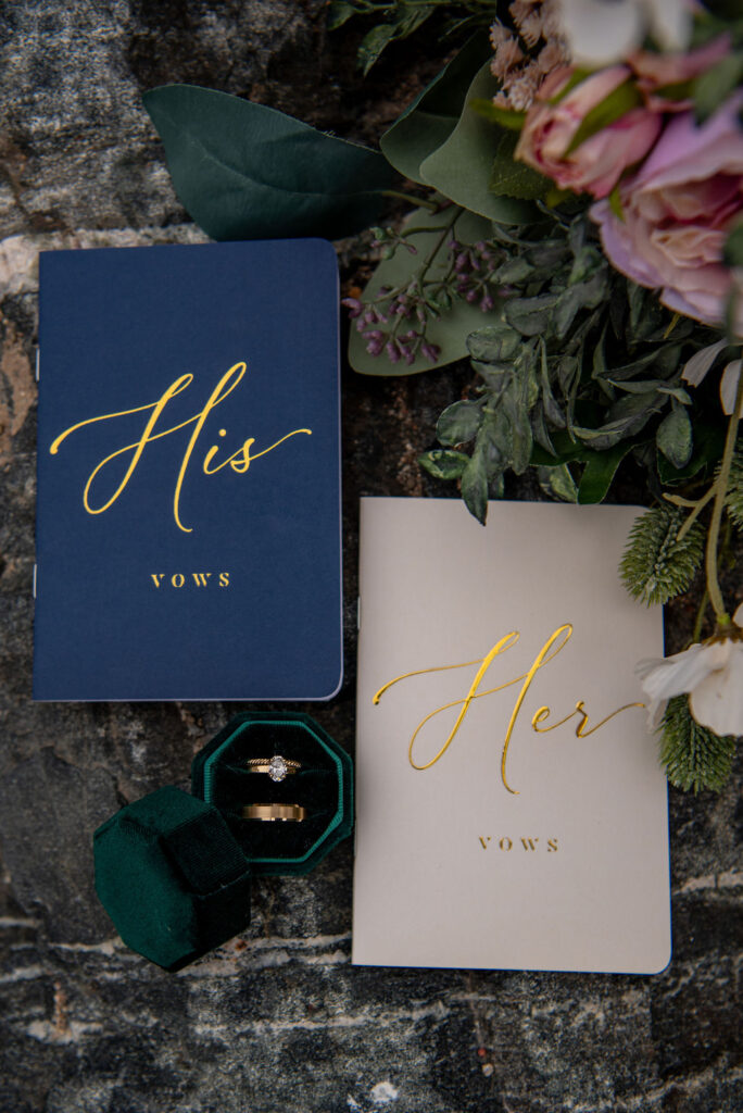 Flat lay of vow books and wedding rings, showing how to plan an elopement ceremony with meaningful personal details.