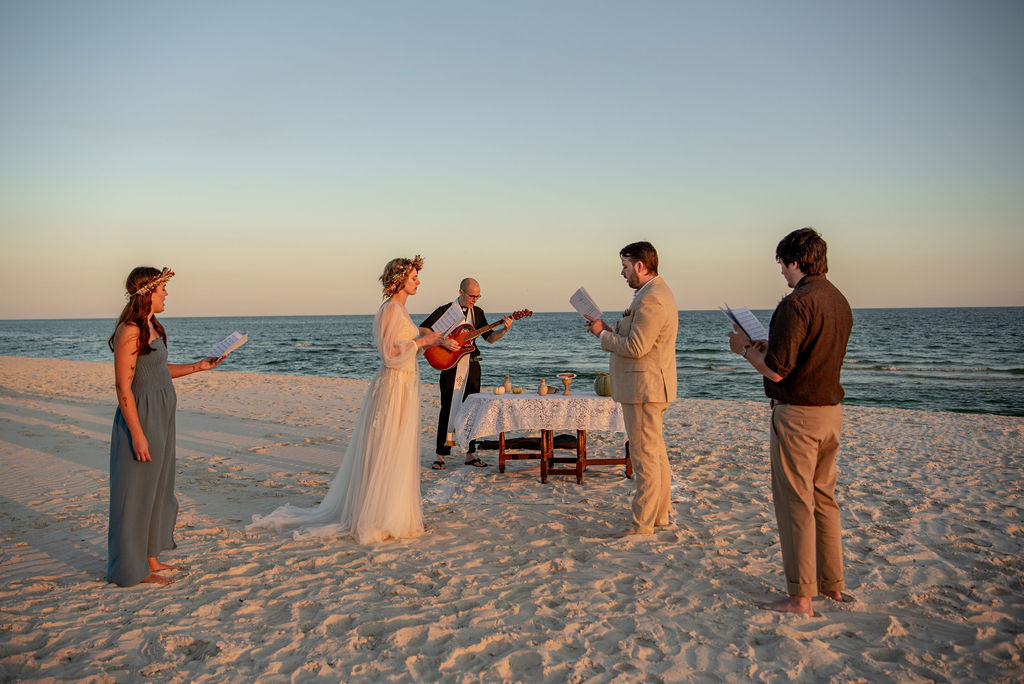 A picturesque beach wedding scene featuring a couple at the altar, with guests watching and the waves gently crashing nearby. This is a small wedding with only two guests. Showing how to plan an elopement ceremony with a few people.